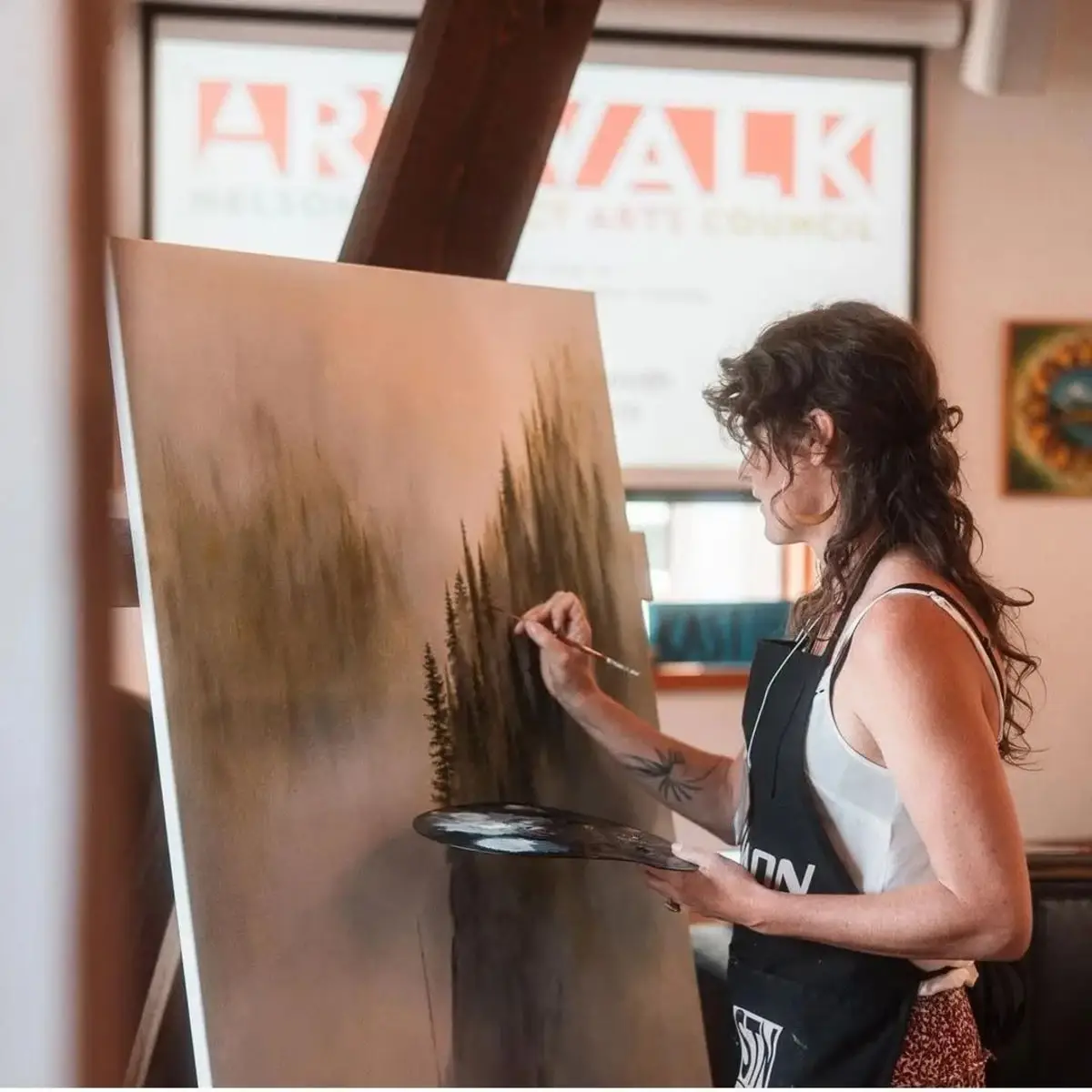 Branda Avis painting an atmospheric forest landscape at an easel