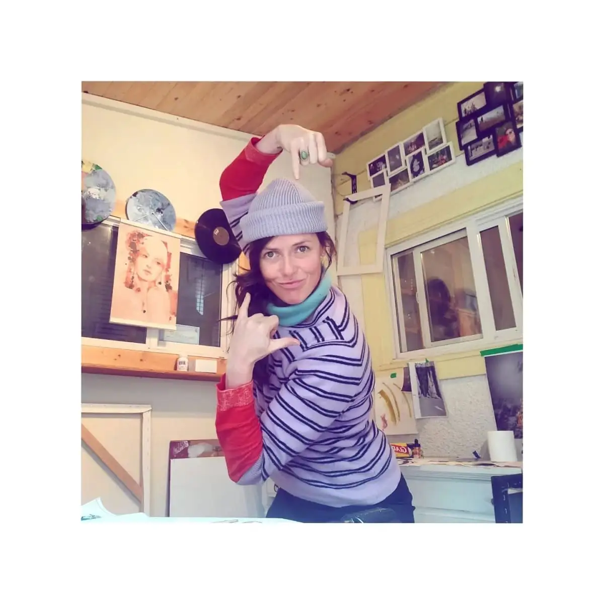 Branda Avis posing in a kitchen wearing a striped top and a knitted hat