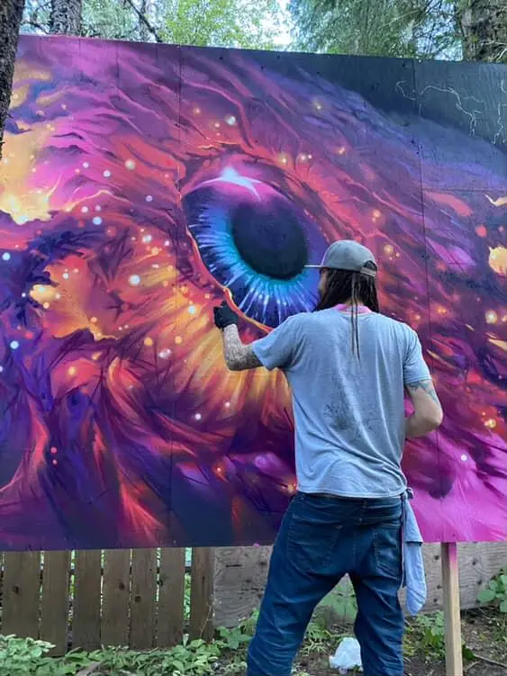Aaron Brown working on a large-scale eye mural