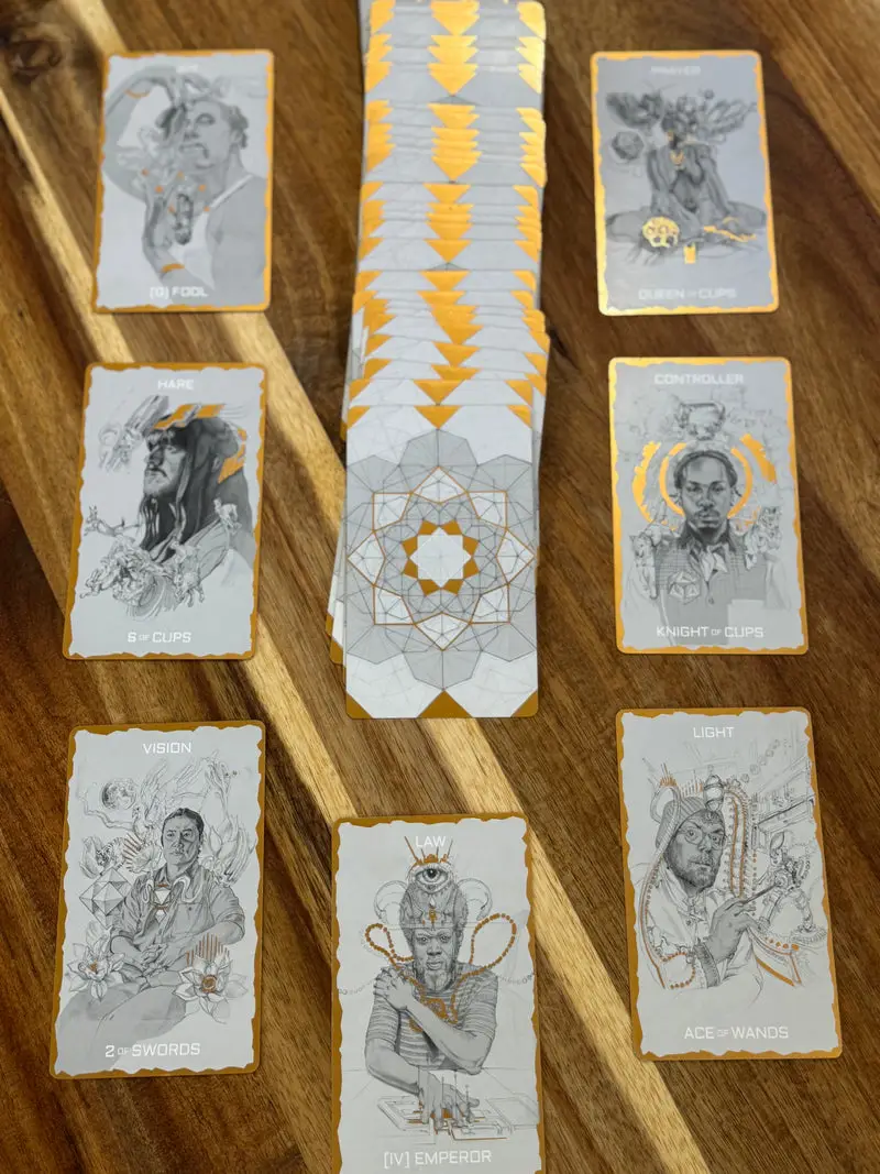 Tarot One cards showing hand-drawn characters and gold details beside a spread of geometric card backs
